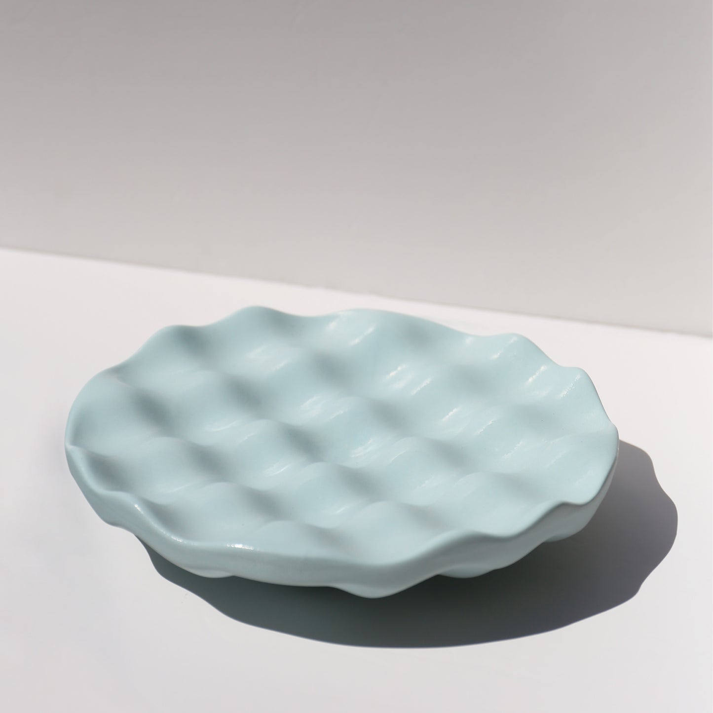 Light blue ceramic dish with textured surface on a white background