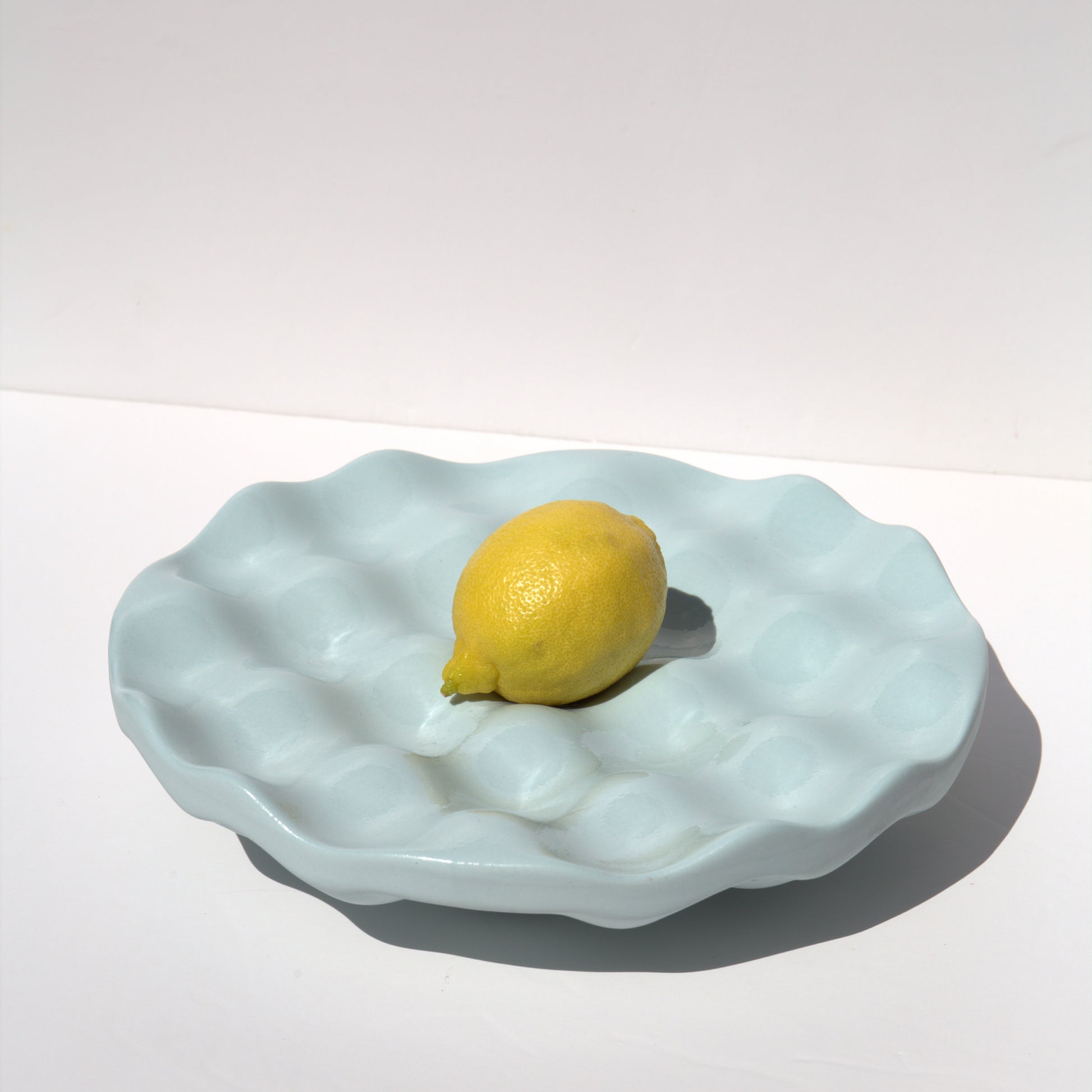 Dune Bowl Light blue with a lemon on a white background